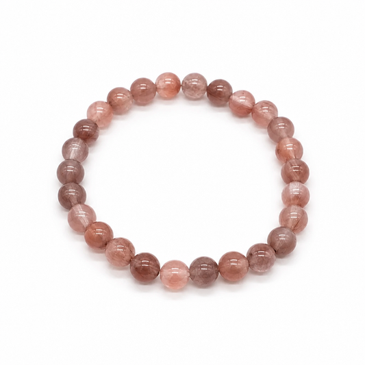 Close-up of clear quartz beads with red and pink hematite fibres