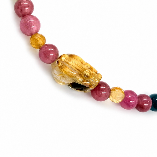 Close-up of rainbow tourmaline 4mm beads in pink green teal gold and blue