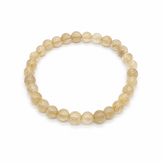 Close-up of clear quartz beads with golden rutile needles