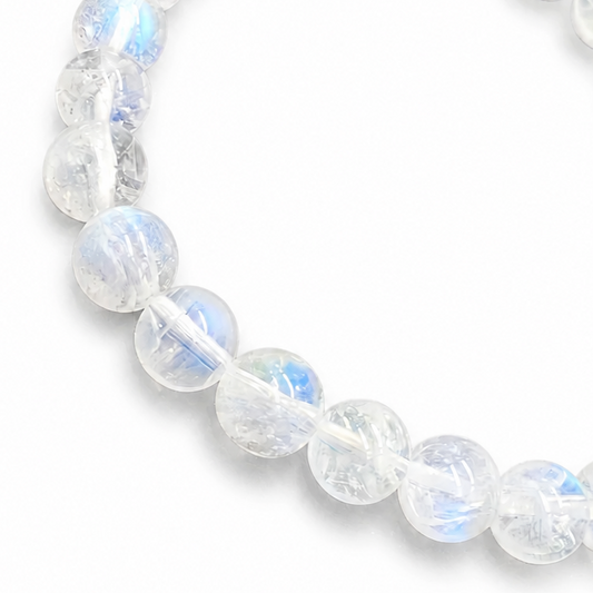 Close-up of blue-white adularescence drifting across translucent Madagascar Moonstone beads
