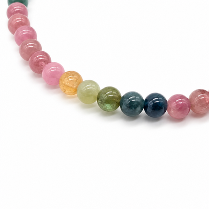 Macro of rainbow tourmaline beads in pink, yellow, green and indigo