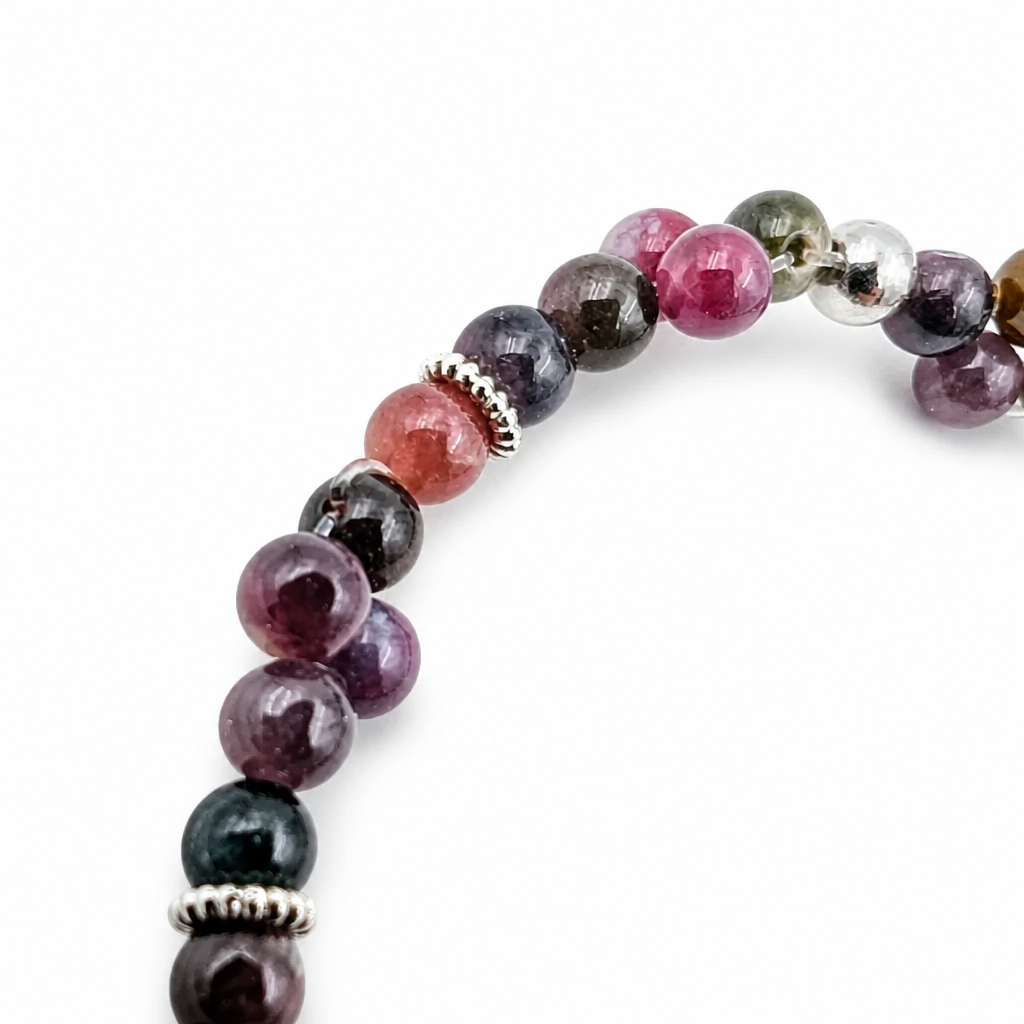 Section of the bracelet with a silver daisy spacer between peach and deep teal beads