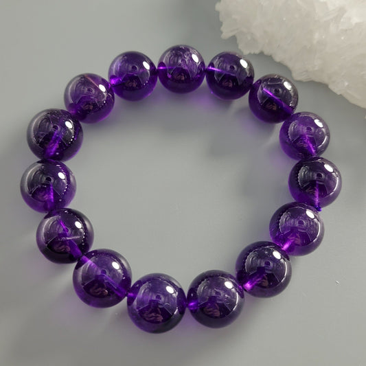 Purple beaded bracelet on a light gray background