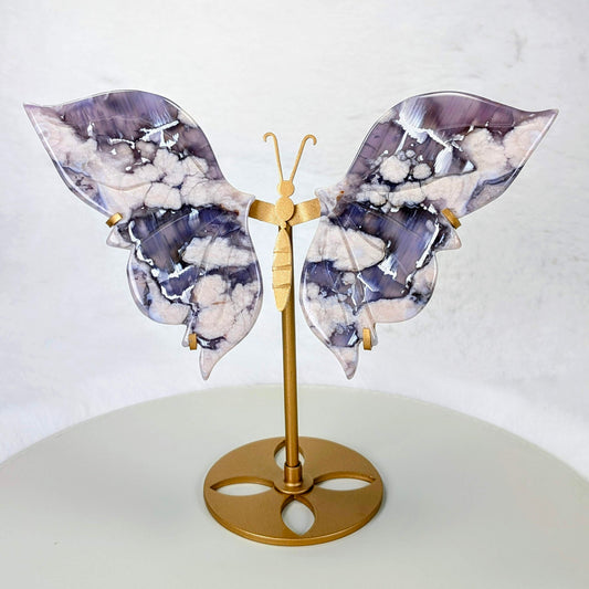 AuraLuneCrystal Indigo Bloom butterfly specimen with deep blue flowery wings and white inclusions on a tiered gold-toned butterfly stand.