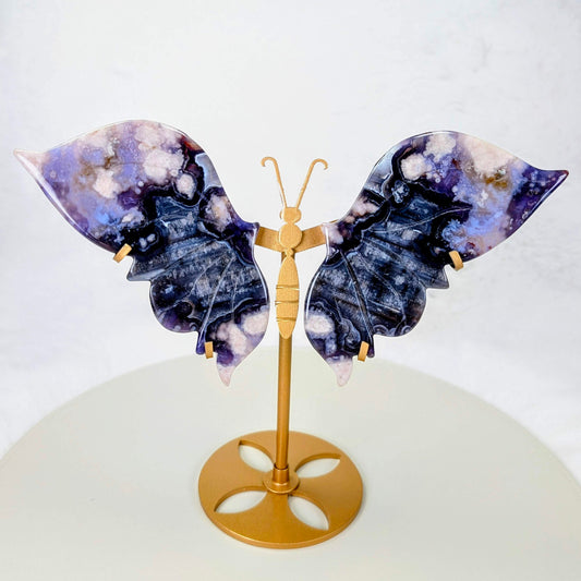 AuraLuneCrystal Blue Flower Agate butterfly specimen with deep purple-blue wings and white petal inclusions on a gold-toned butterfly-shaped stand.