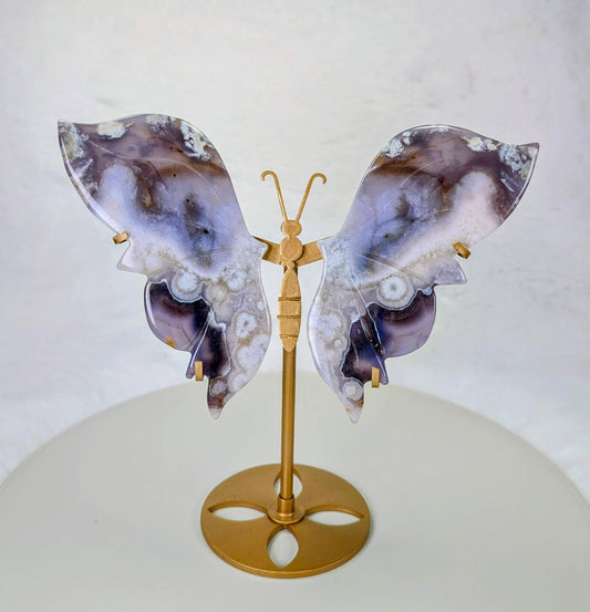 AuraLuneCrystal Azure Metamorphosis butterfly specimen with indigo-blue wings and white floral inclusions on a gold butterfly stand.