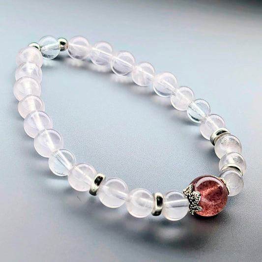 AuraLuneCrystal Heart Blossom bracelet featuring a dark red Strawberry Quartz focal bead, soft pink rose quartz, and clear quartz with silver accents.