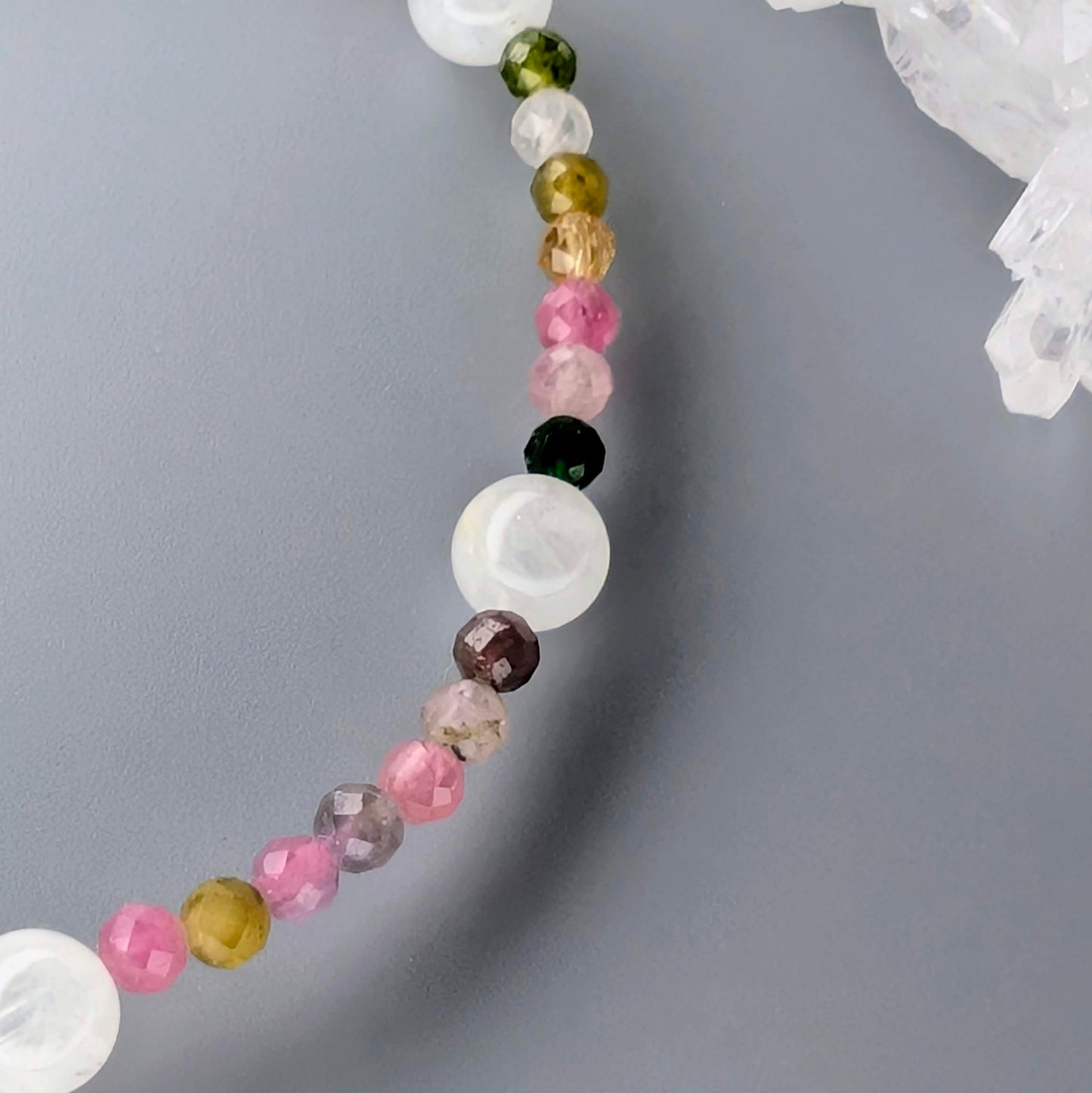 AuraLuneCrystal Prismatic Moonlight bracelet featuring small faceted colorful tourmaline beads and larger white Madagascar moonstone beads with blue flash.
