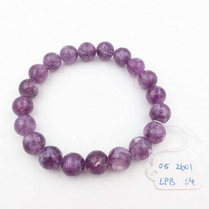 Deep violet lepidolite beaded bracelet laid flat on a white background