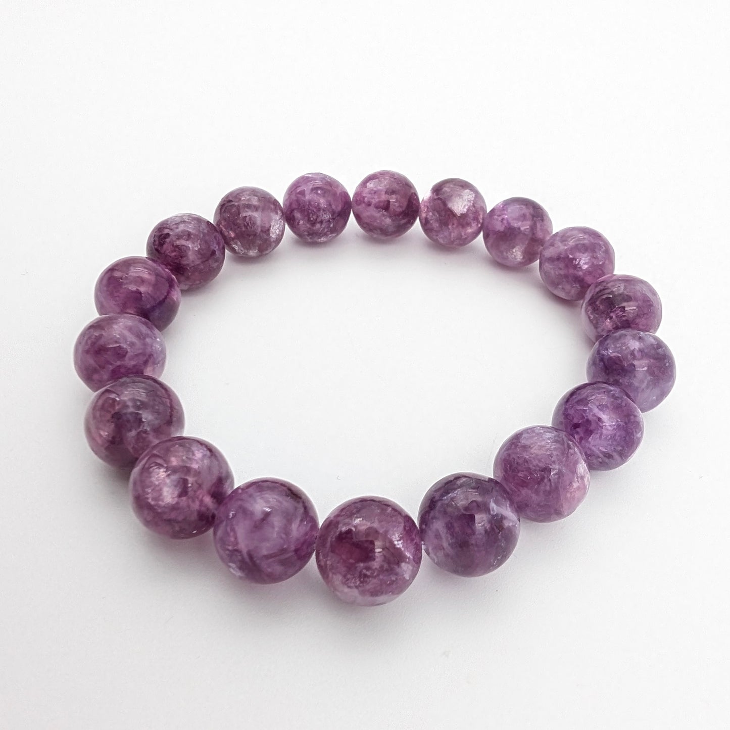 Violet lepidolite beaded bracelet resting in a soft circle