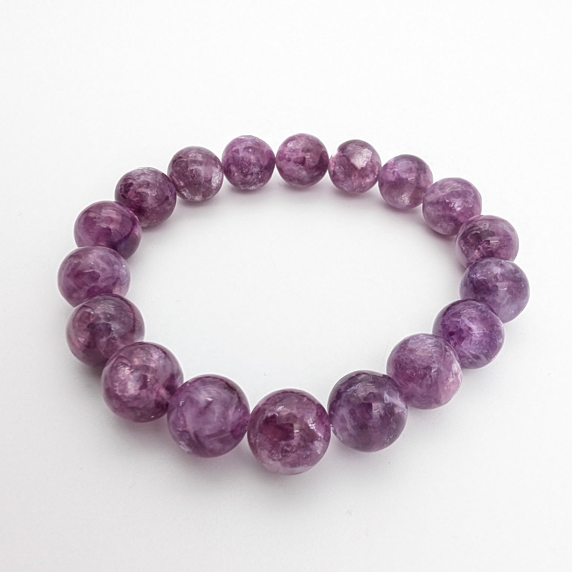 Violet lepidolite beaded bracelet resting in a soft circle