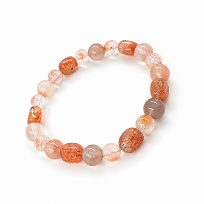 Red-orange Sunstone and Rabbit Hair Quartz bracelet with deep warm tones on white