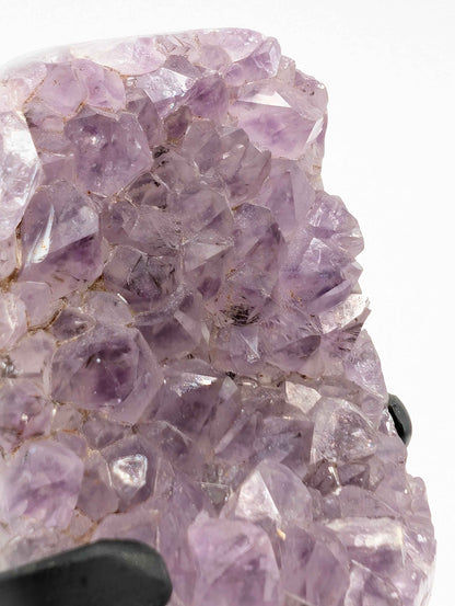 Side view of the lavender druzy amethyst spire showing full height on wooden stand
