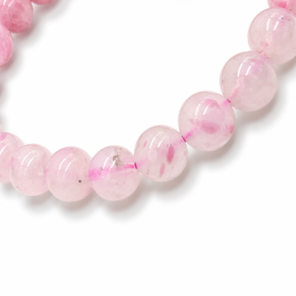 Soft dusty pink rhodonite beads at the pale end of the hand-arranged gradient strand