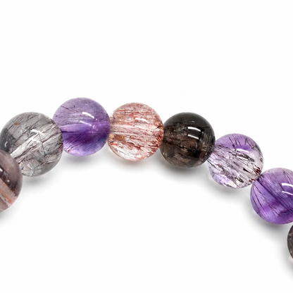 Rutile and cacoxenite inclusions inside a clear Super 7 bead