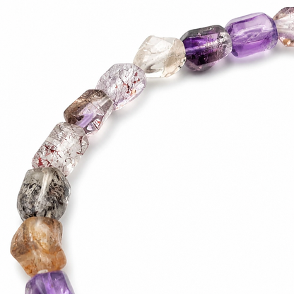 Deep violet amethyst nugget beside a smoky quartz bead on the Super Seven strand