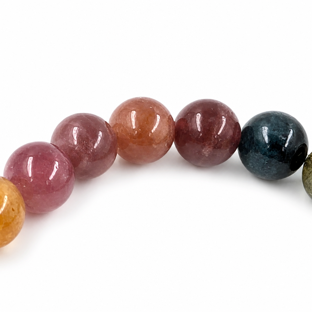 Angled view of the Rainbow Tourmaline bracelet catching natural light across each bead