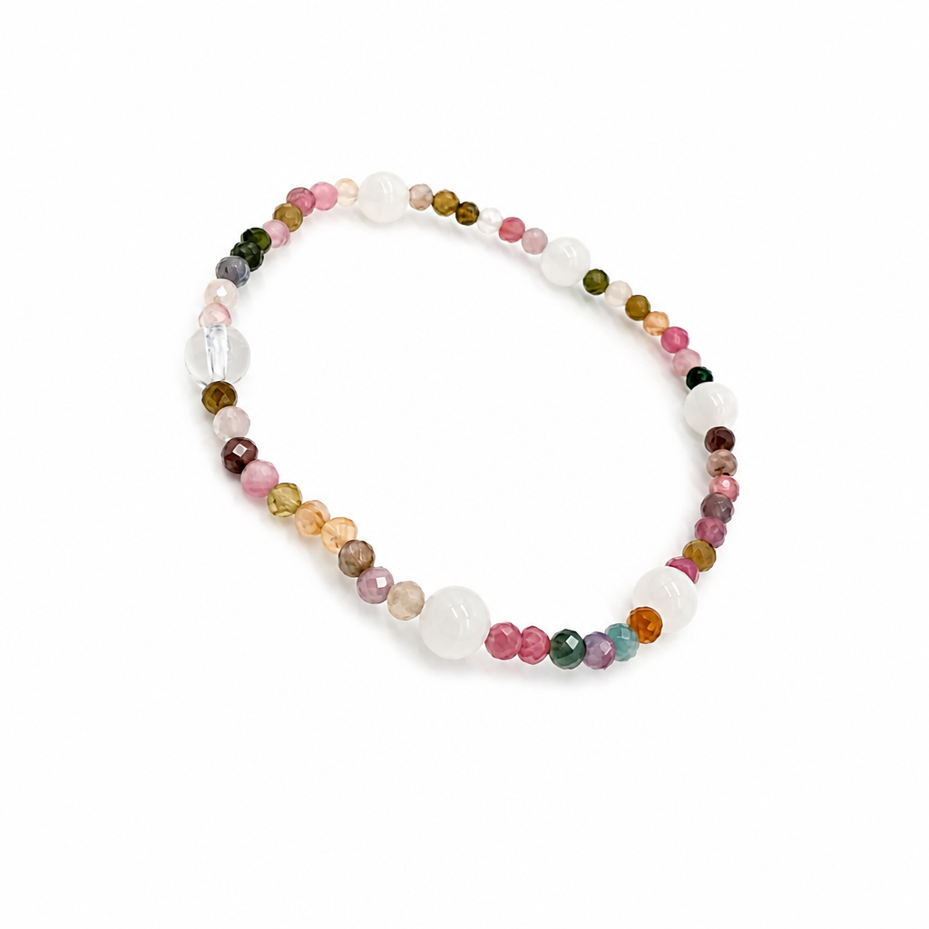 Moonstone bead showing blue adularescence beside rainbow tourmaline