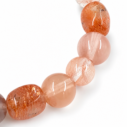 Angled view of the red sunstone bracelet catching warm light across each bead