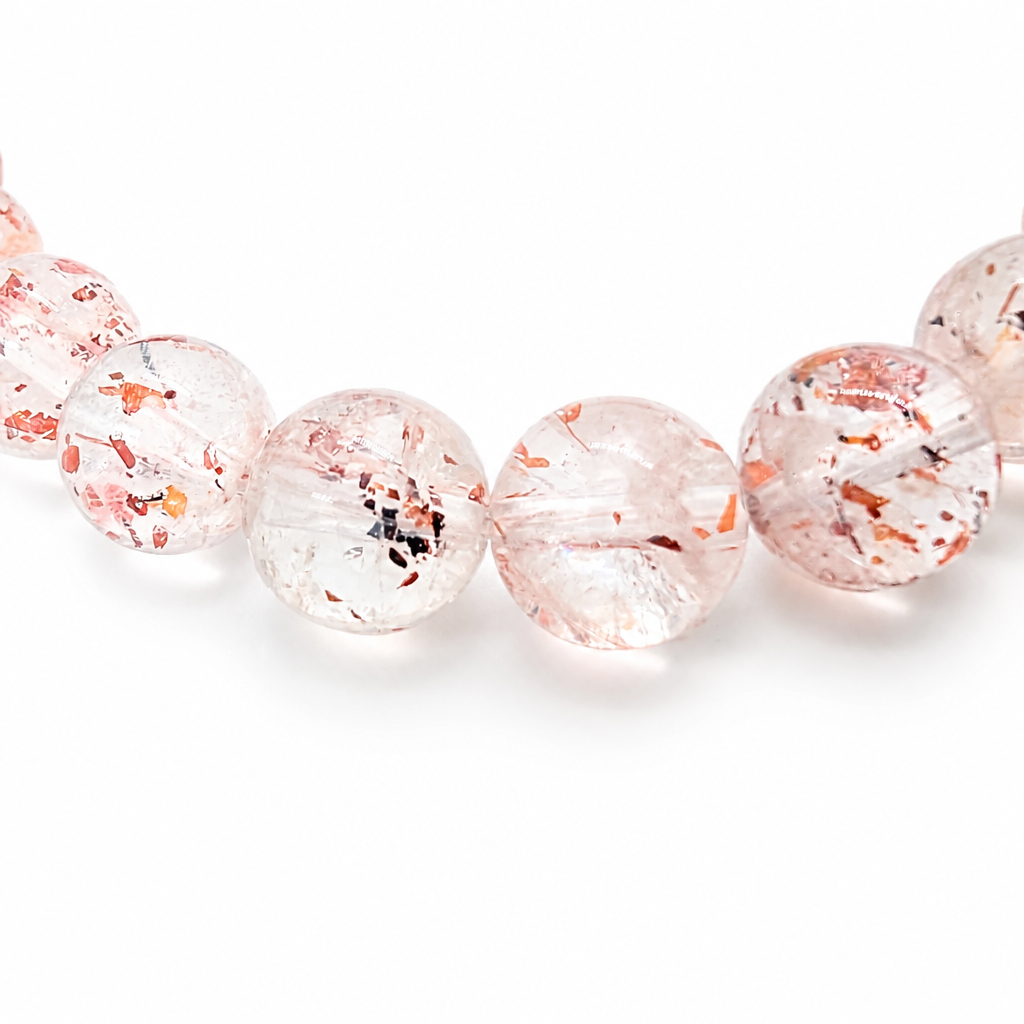 Translucent quartz beads with warm red inclusions on white