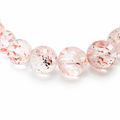 Translucent quartz beads with warm red inclusions on white