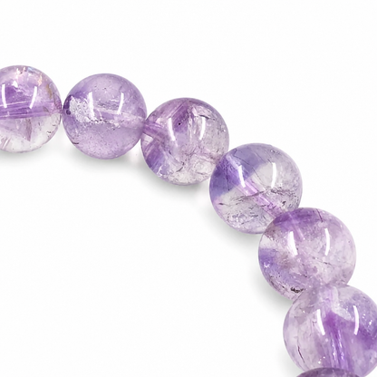 Gold rutile and red lepidocrocite threads visible inside an amethyst super seven bead
