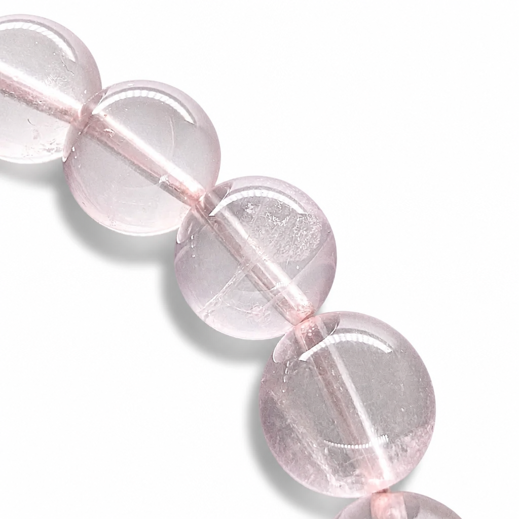 Side view of the Madagascar Rose Quartz bracelet showing 7.5mm bead presence on a pale surface