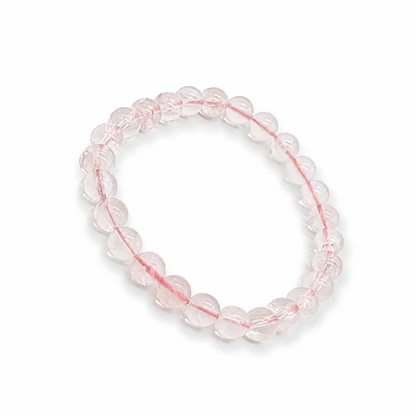 Close-up of high-clarity ice-grade Madagascar Rose Quartz beads glowing soft pink in light