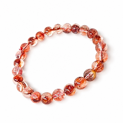 Red-orange hematite catching light inside a quartz bead