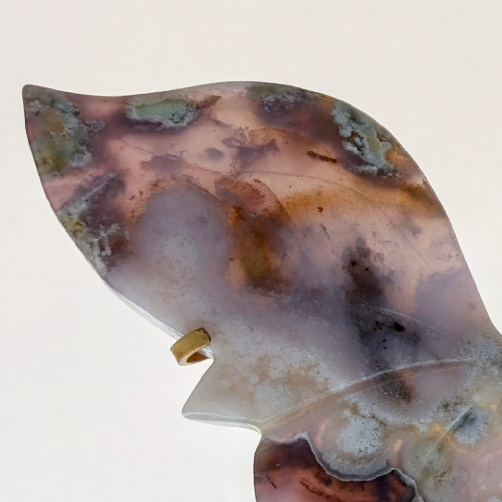 Side view of the blue agate butterfly on its gold stand