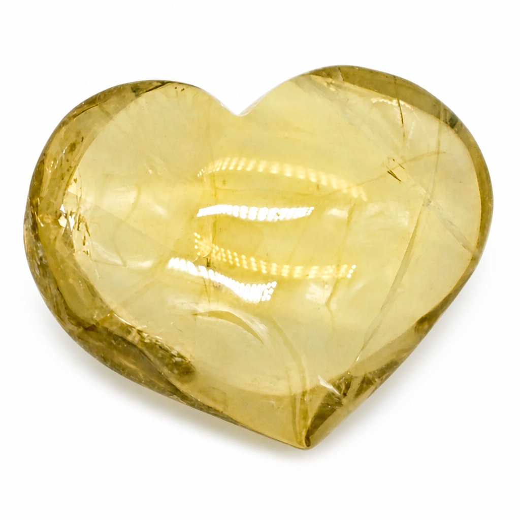 Hand-carved citrine heart with mirror polish resting on a pale surface