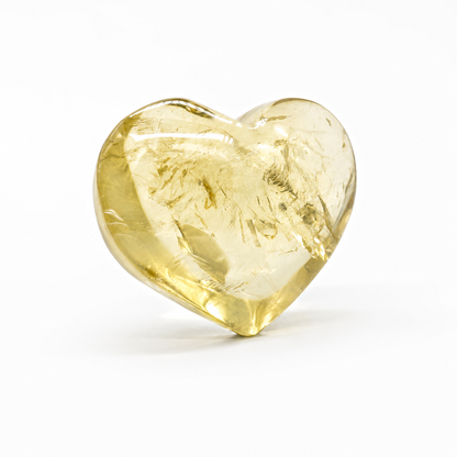 Hand-carved citrine heart with honey-gold polish resting on a pale surface