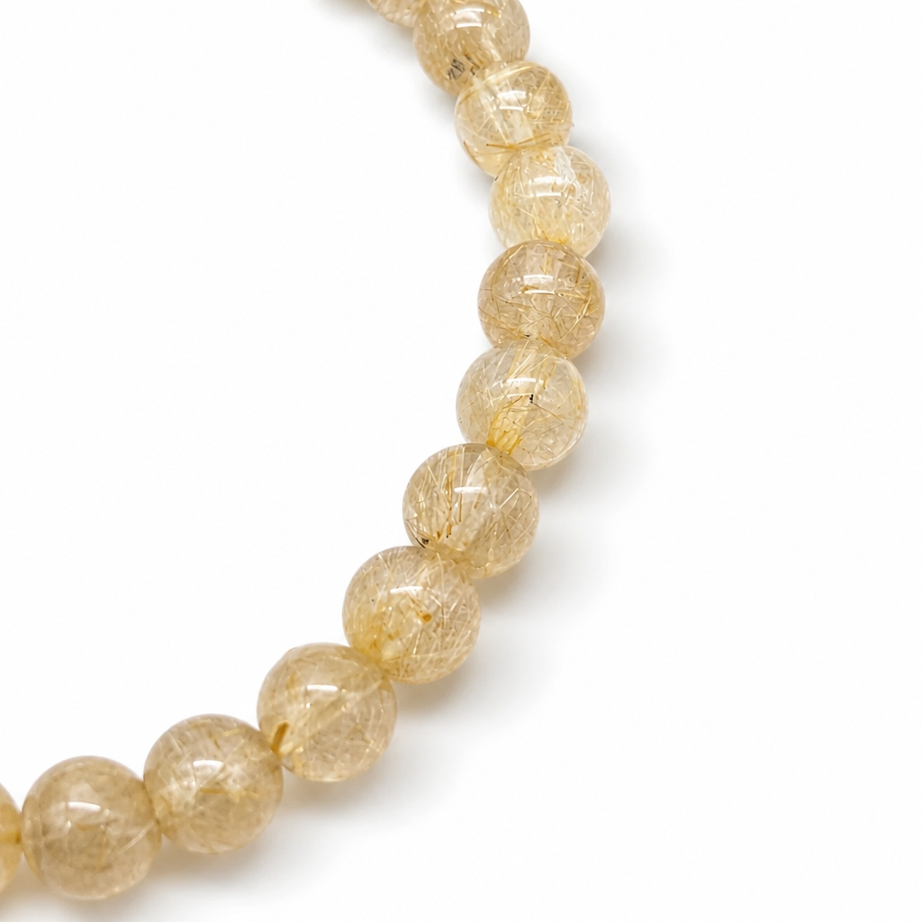 Golden needles catching light inside a quartz bead