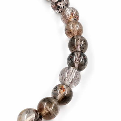 Black Super Seven bracelet resting flat showing fine 5.5mm bead size and dark tone