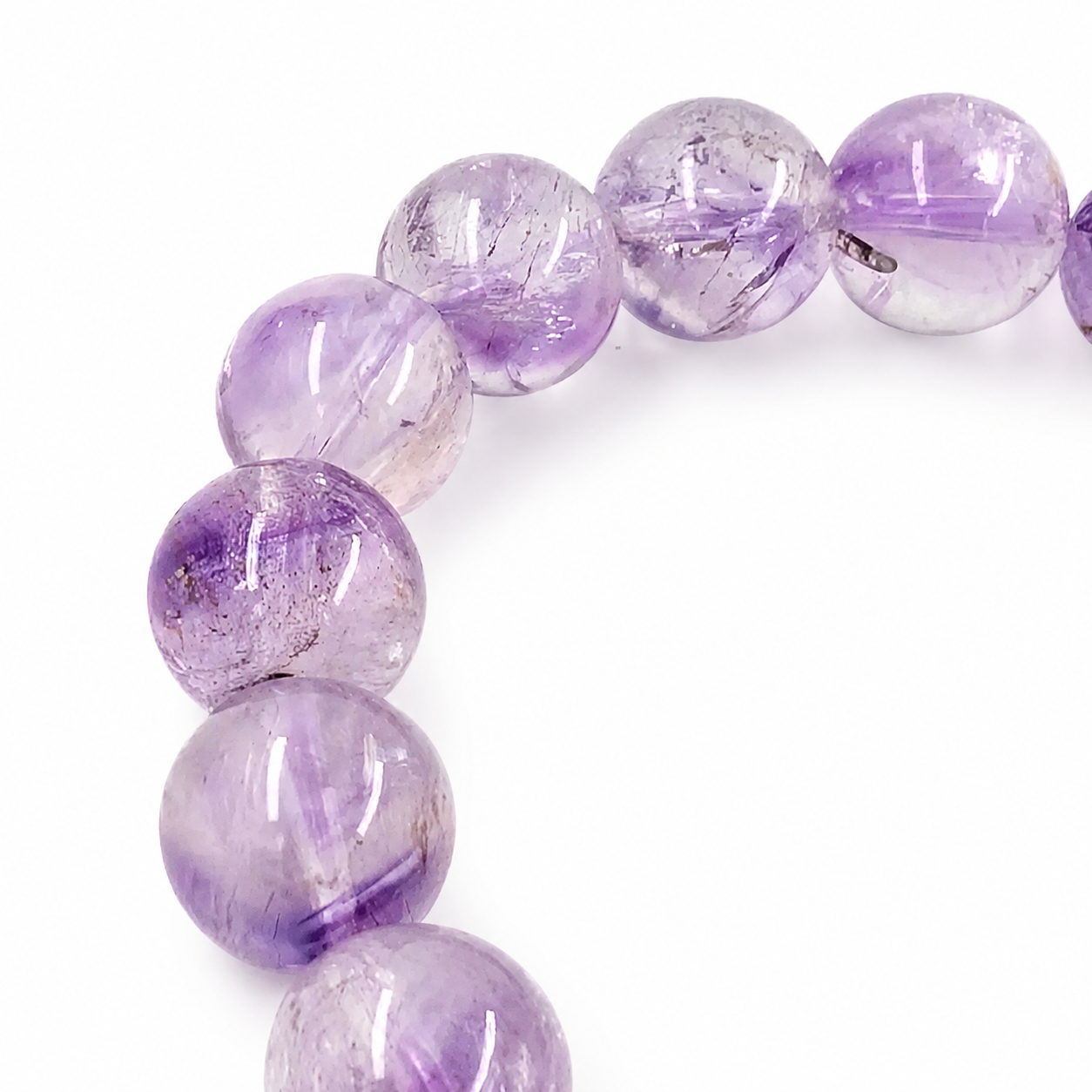 Super Seven Melody Stone bracelet resting flat showing all four sizes comparison