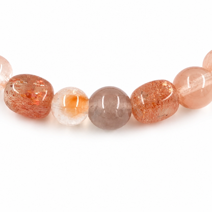 Rose-gold rutile threads visible inside water-clear rabbit hair quartz alongside red sunstone