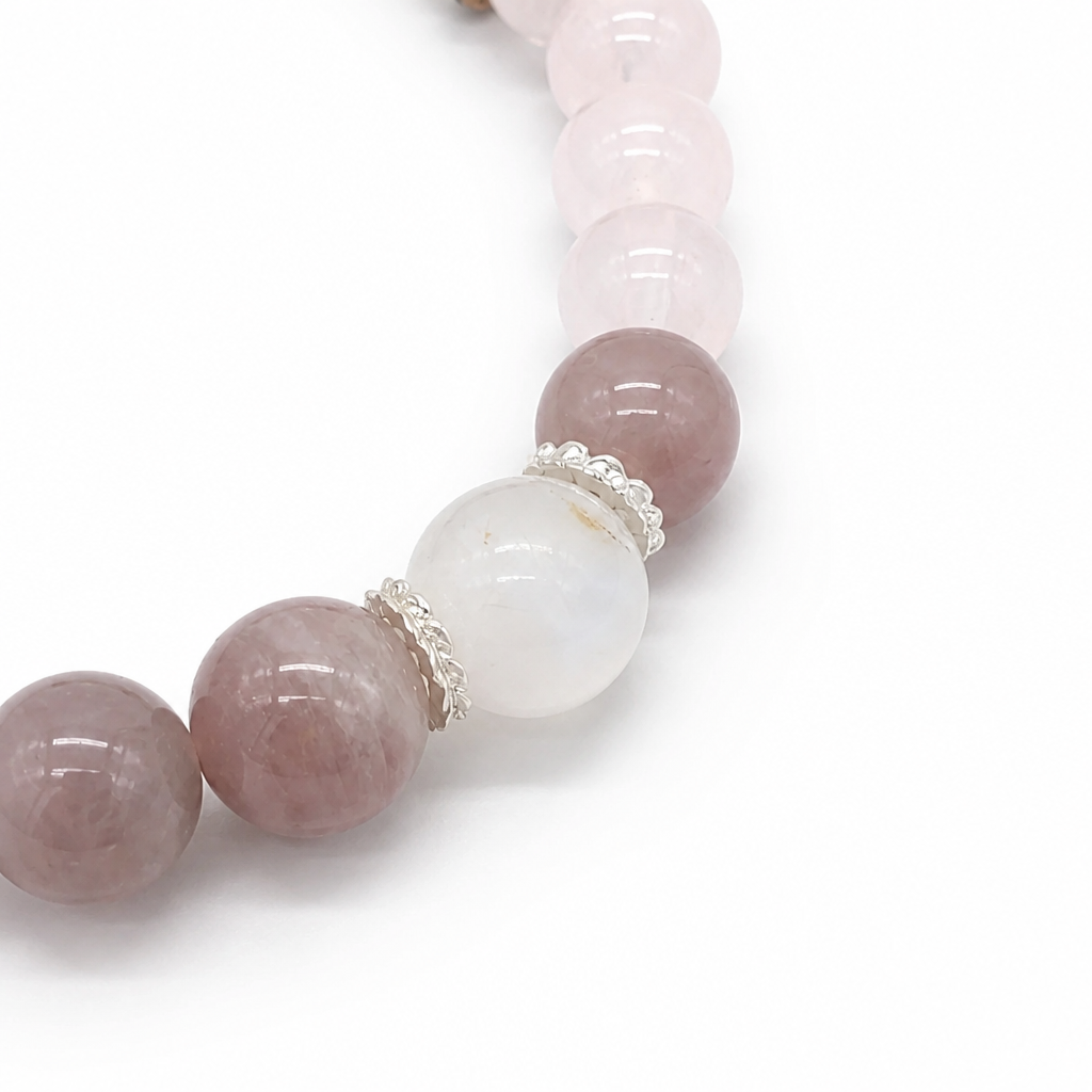 Detail of delicate silver filigree spacers catching light between crystal beads