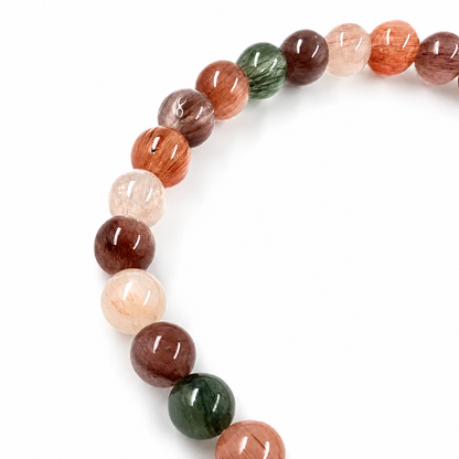 Angled view of the Rabbit Hair Quartz bracelet catching light across each bead