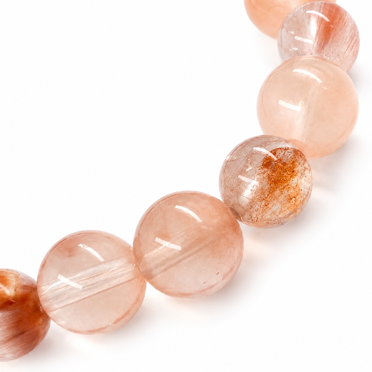 Rose-gold rutile threads visible inside water-clear rabbit hair quartz beads