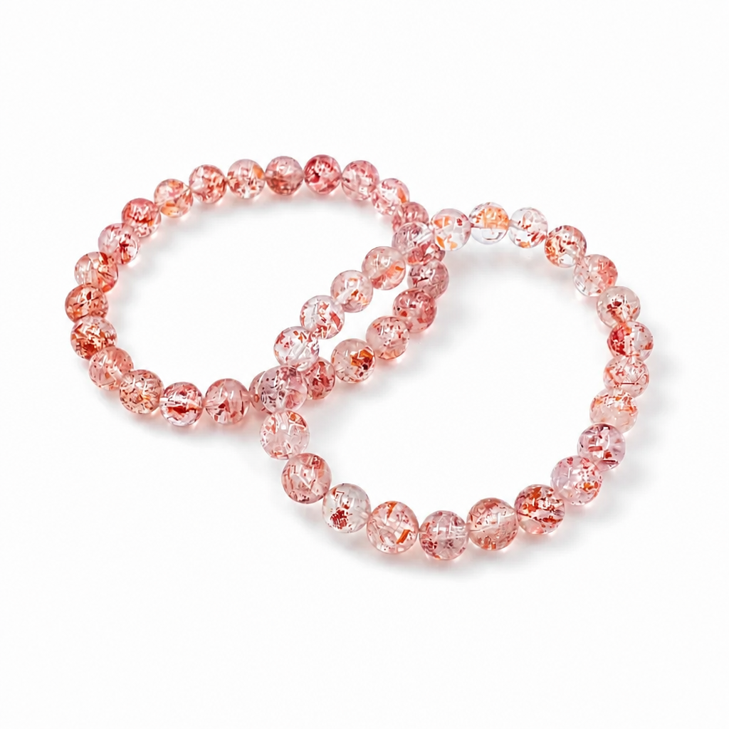 Close-up of clear quartz beads with strawberry-red lepidocrocite inclusions