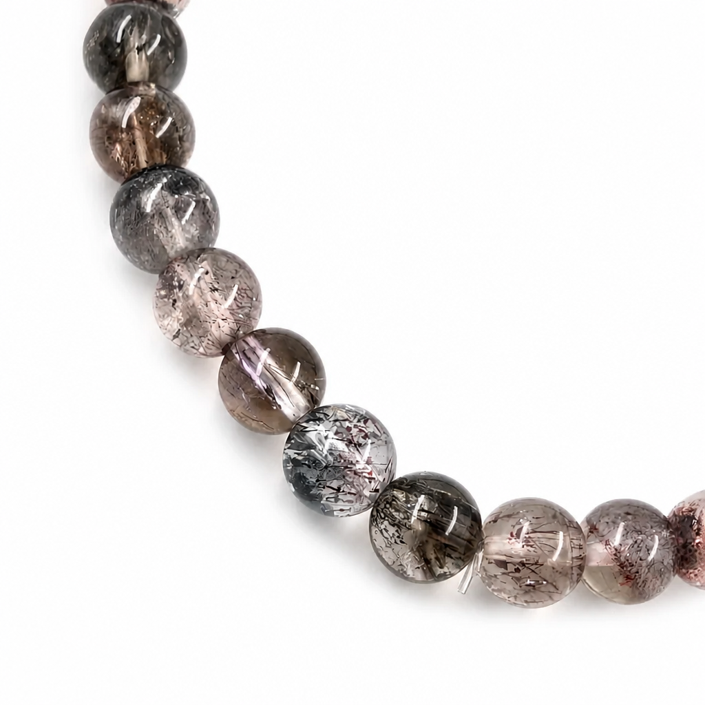 Side view of the 5.5mm Black Super Seven Melody Stone bracelet on a pale surface