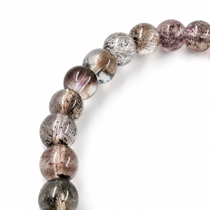 Detail of smoky and gold mineral threads visible inside black super seven beads