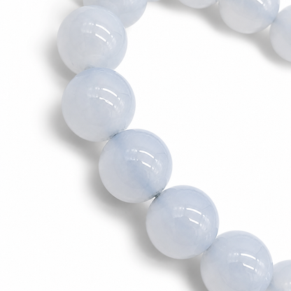 Close-up of smooth waxy lustre on soft sky-blue Blue Chalcedony 10mm beads in natural light