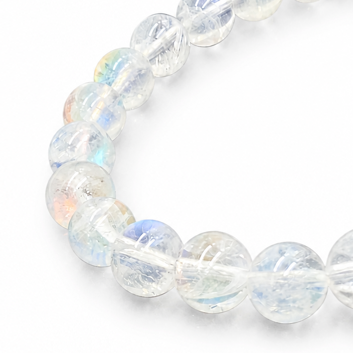 Side view of the 6mm Madagascar Rainbow Moonstone bracelet on a pale surface
