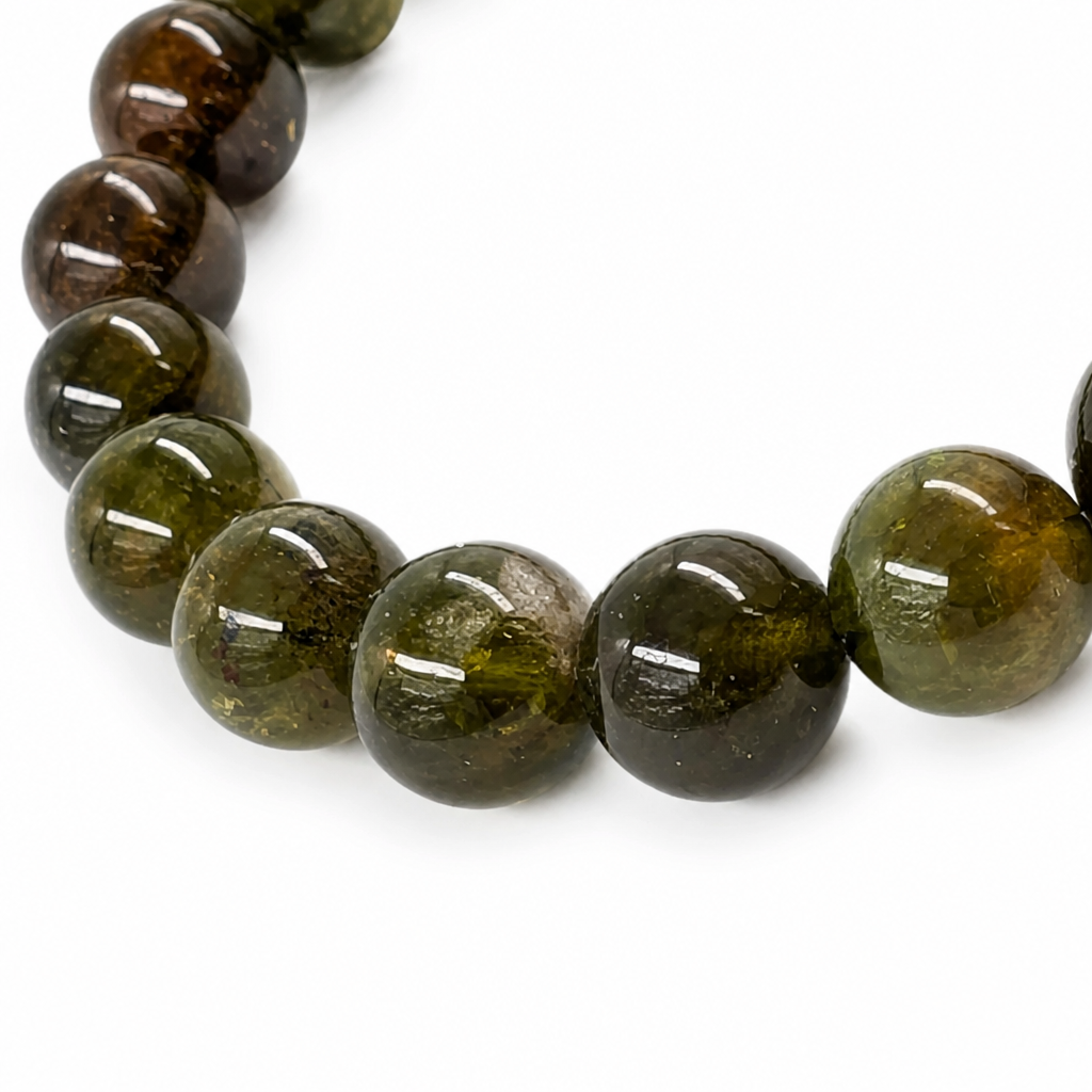 Side view of the 8.5mm Green Tourmaline Verdelite bracelet on a pale surface