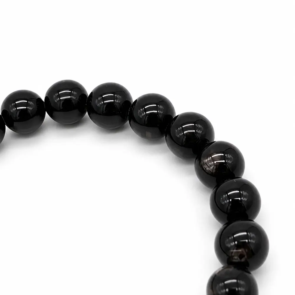 Macro detail of hypersthene beads showing the silver-grey schiller band catching directional light