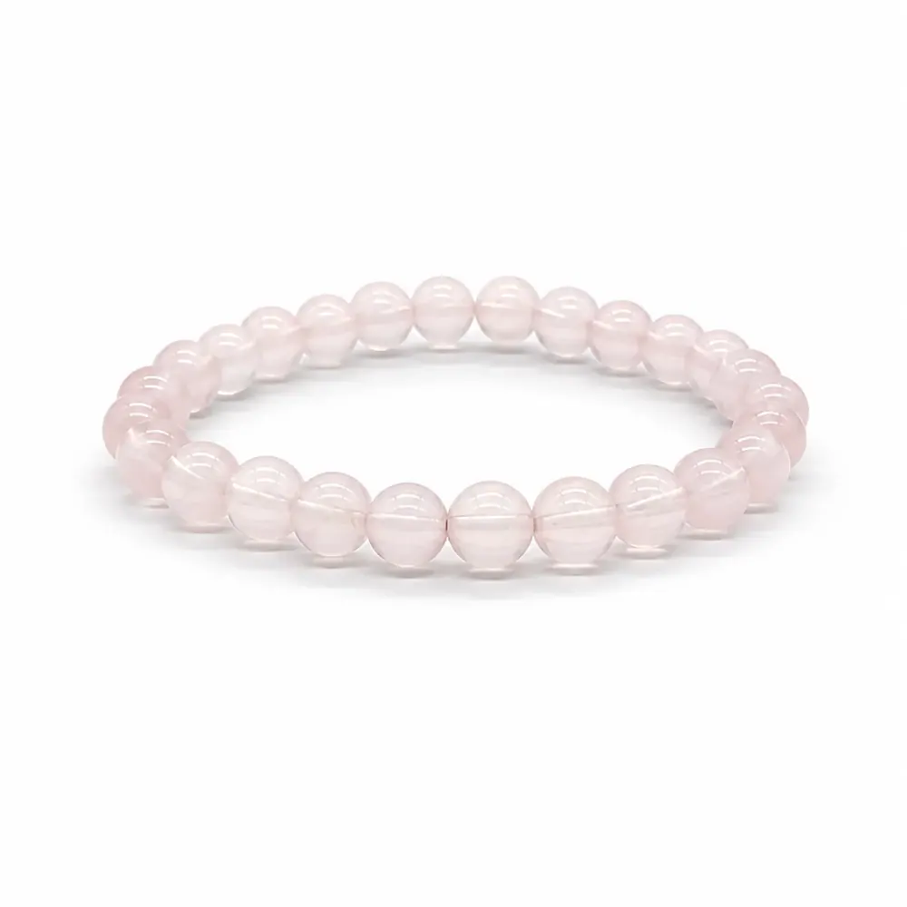 Rose quartz bracelet in pale pink beads resting on white