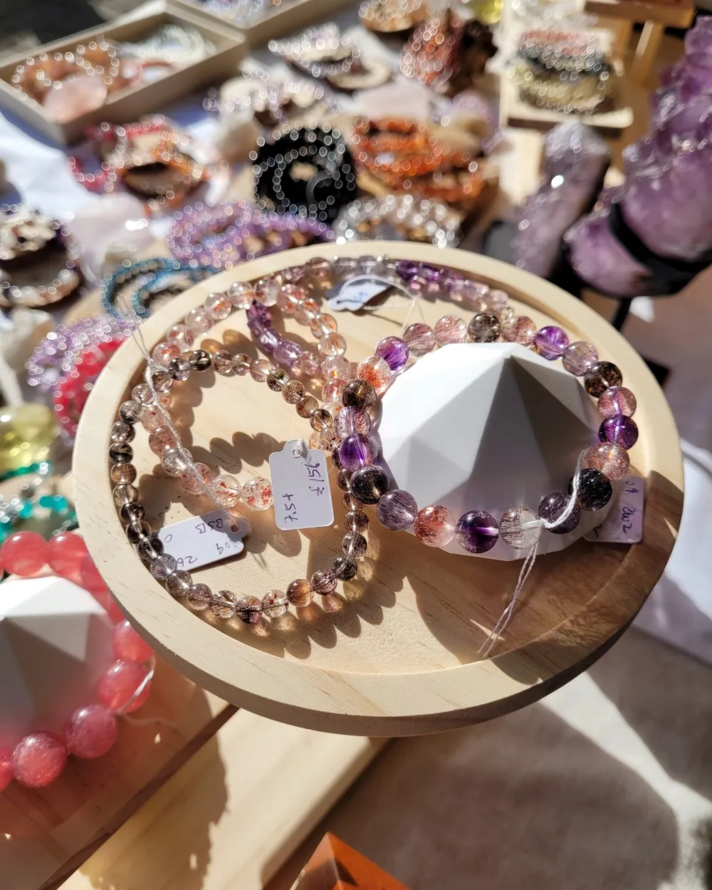 Close-up of natural crystal bracelets on a wooden display stand