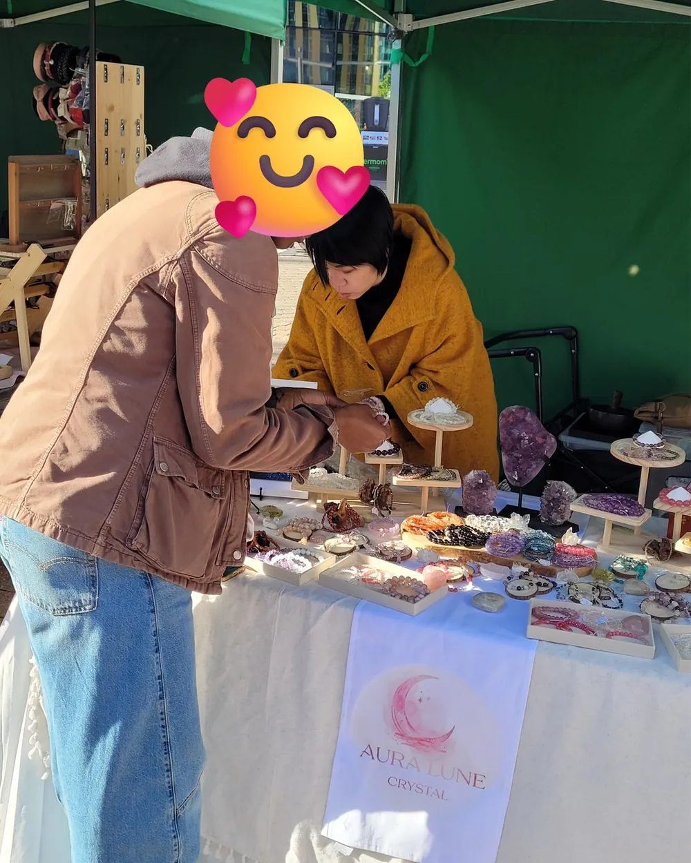 A customer trying on bracelets at the AuraLune stall