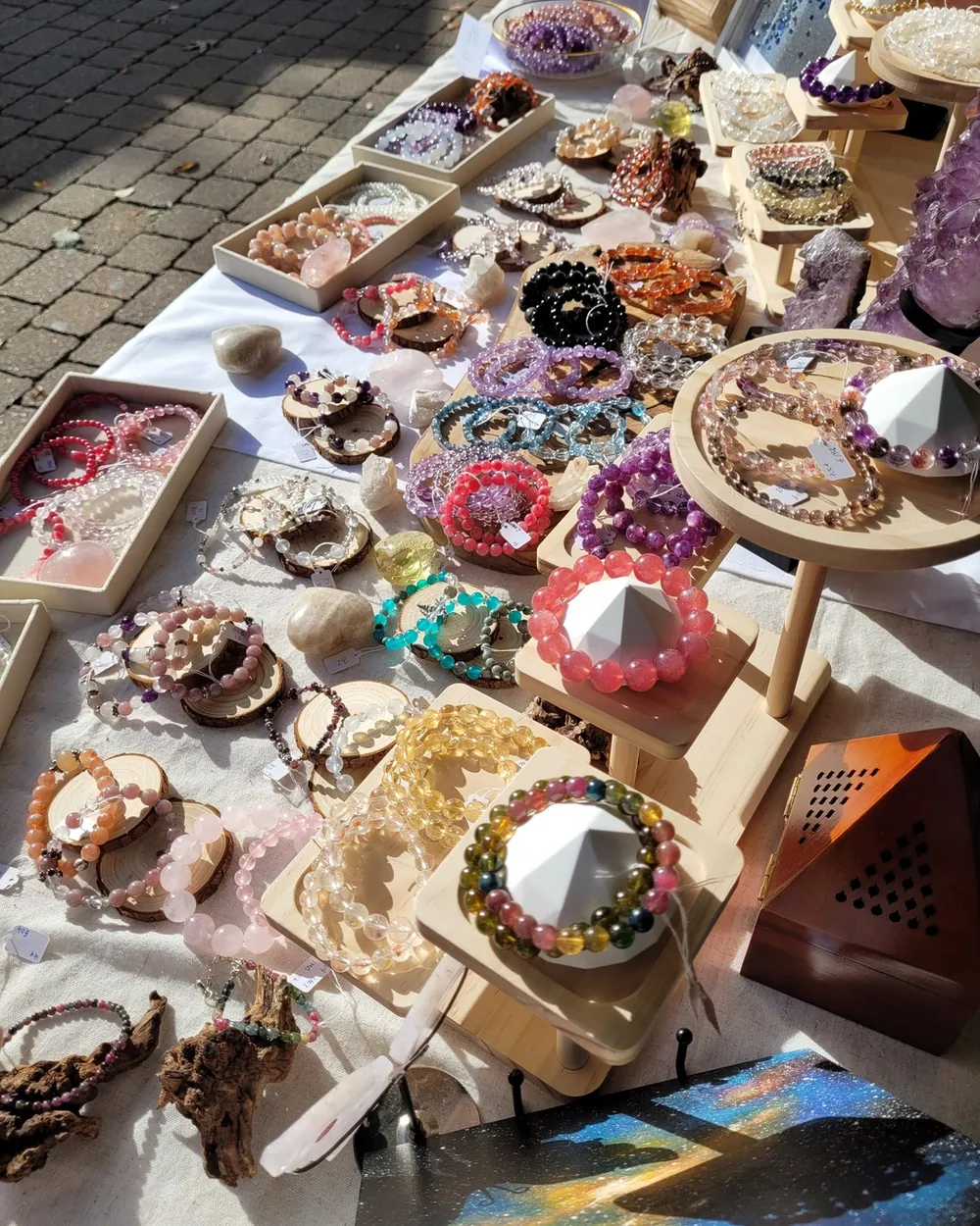 Handmade crystal bracelets displayed on the AuraLune market stall